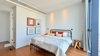 Modern bedroom with stylish decor and large window offering natural light.