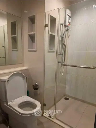 Modern bathroom with glass shower enclosure and sleek fixtures.