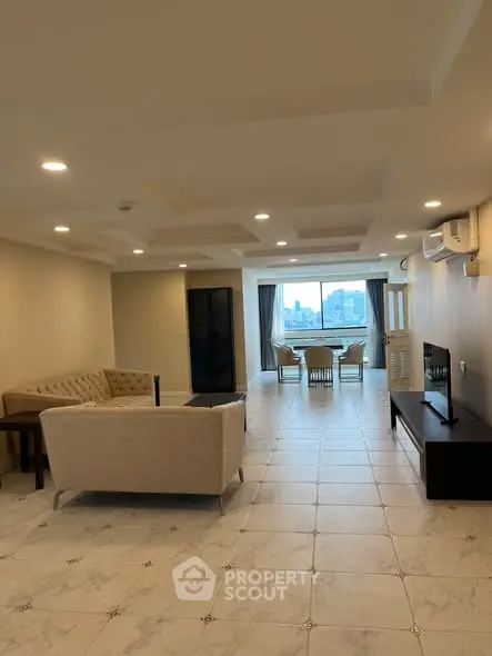 Spacious living room with modern furniture and city view, perfect for urban living.