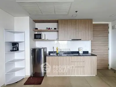 Modern kitchen with sleek cabinetry and stainless steel appliances in a contemporary apartment.