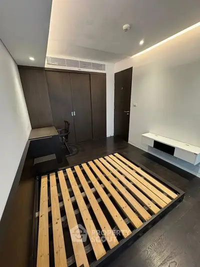 Modern bedroom with sleek wooden flooring and built-in wardrobe