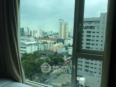 Stunning urban view from a high-rise apartment window, showcasing city skyline and modern architecture.