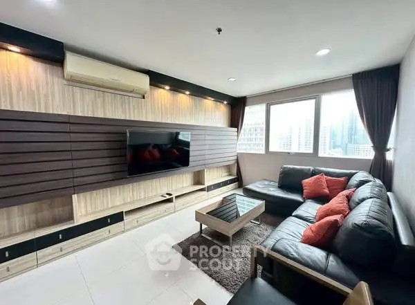 Modern living room with sleek design and city view, featuring a large TV and comfortable seating.