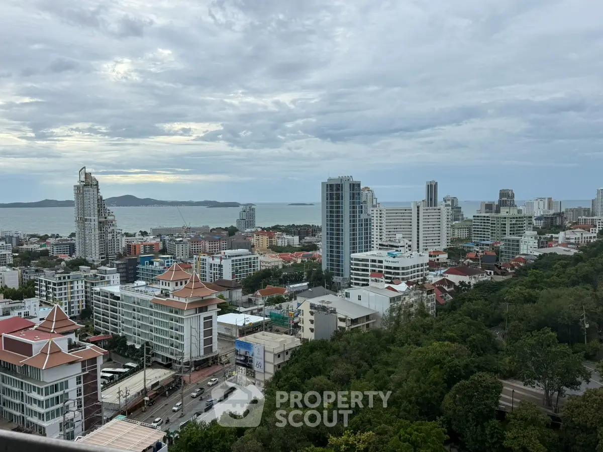 Stunning cityscape view with ocean backdrop and lush greenery, showcasing modern high-rise buildings.