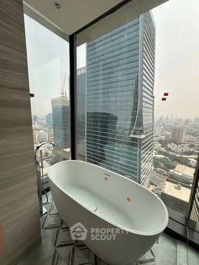Luxurious bathroom with freestanding bathtub and stunning city view from high-rise building.