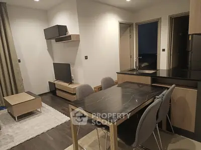 Modern open-plan living room and kitchen with sleek furniture and stylish decor.
