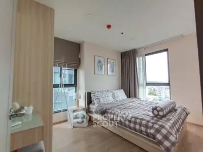 Spacious bedroom with modern decor and large windows offering city views.