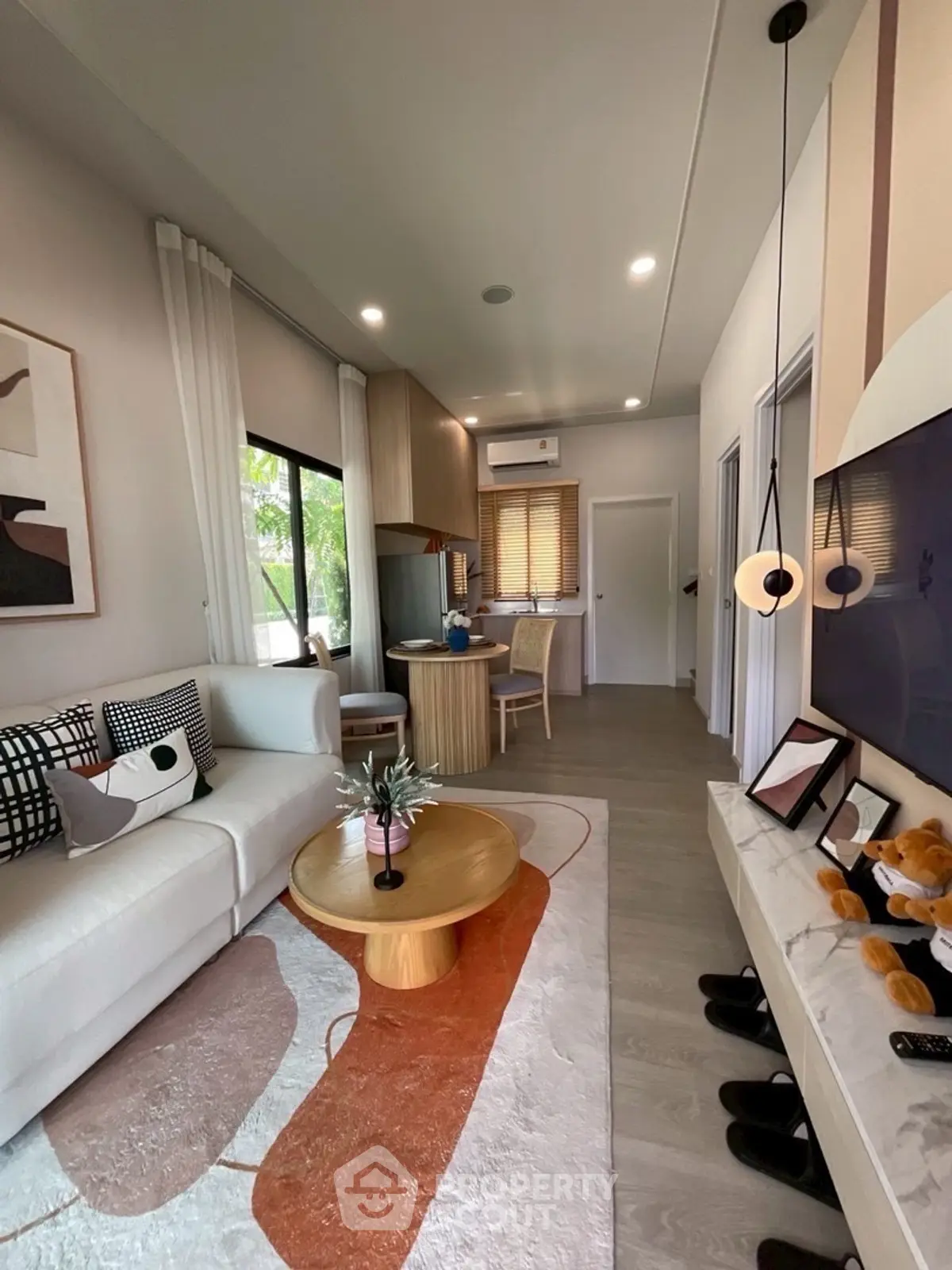 Modern living room with stylish decor and open layout, featuring cozy seating and elegant lighting.