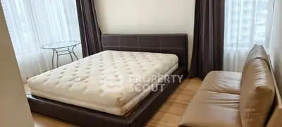 Spacious bedroom with modern furniture and large windows for natural light.