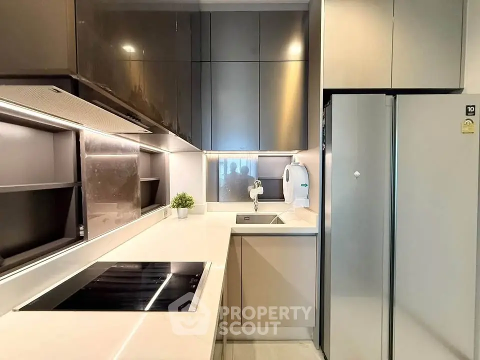 Modern kitchen with sleek cabinetry and built-in appliances, featuring a minimalist design and elegant lighting.