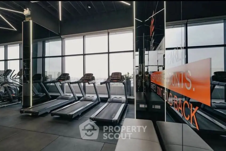 Modern gym with treadmills and large windows offering city views