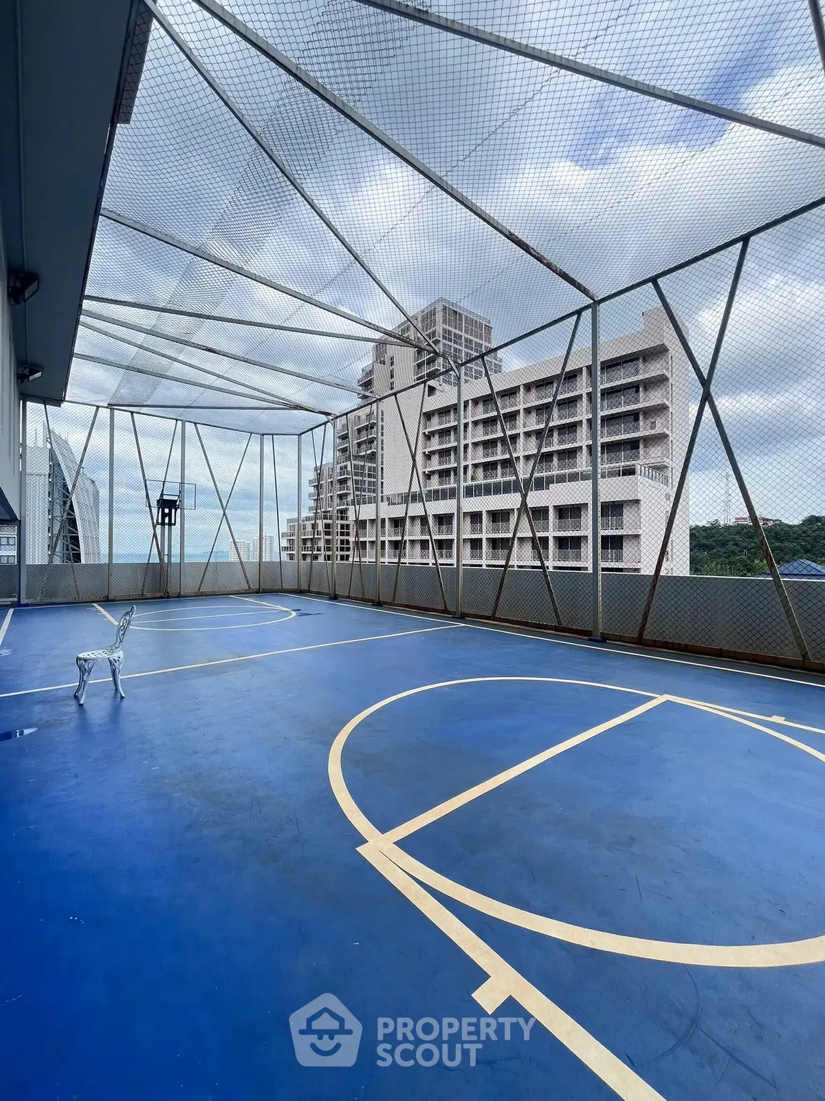 Spacious rooftop basketball court with cityscape view, perfect for sports enthusiasts.