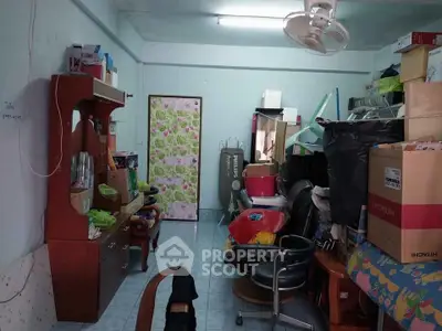 Cluttered room with furniture and boxes, potential for storage or renovation.