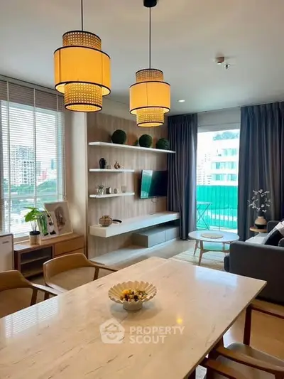 Modern living room with stylish lighting and city view, featuring elegant decor and cozy seating area.
