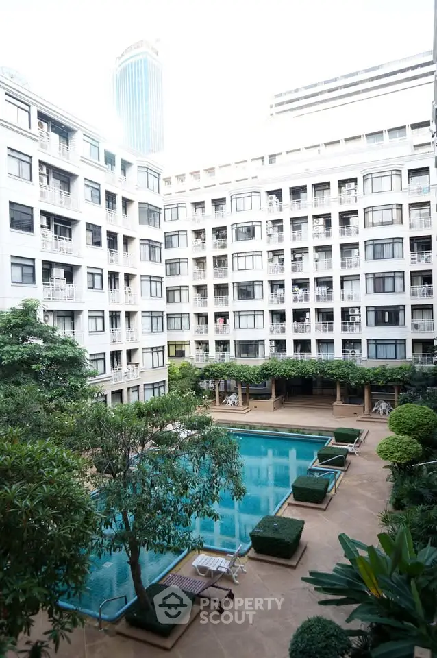 Luxurious apartment complex with a stunning pool and lush greenery, perfect for urban living.
