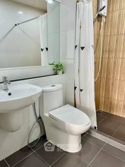 Modern bathroom with shower, toilet, and sink in a sleek design.