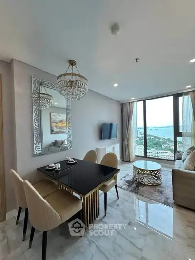 Luxurious living room with stunning sea view, elegant chandelier, and modern decor in high-rise apartment.