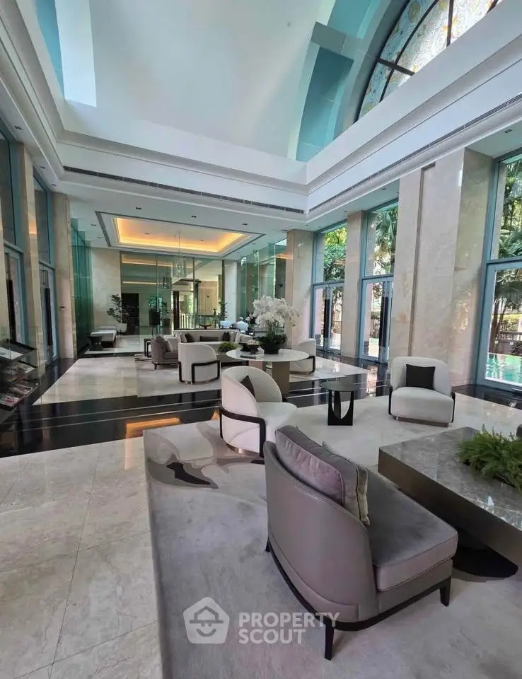 Luxurious lobby with elegant seating and high ceilings in a modern building.