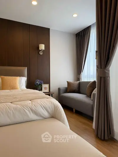 Cozy bedroom with elegant decor and natural light, featuring a comfortable bed and stylish seating area.
