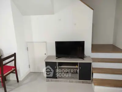 Modern living room with TV stand and staircase, minimalist design