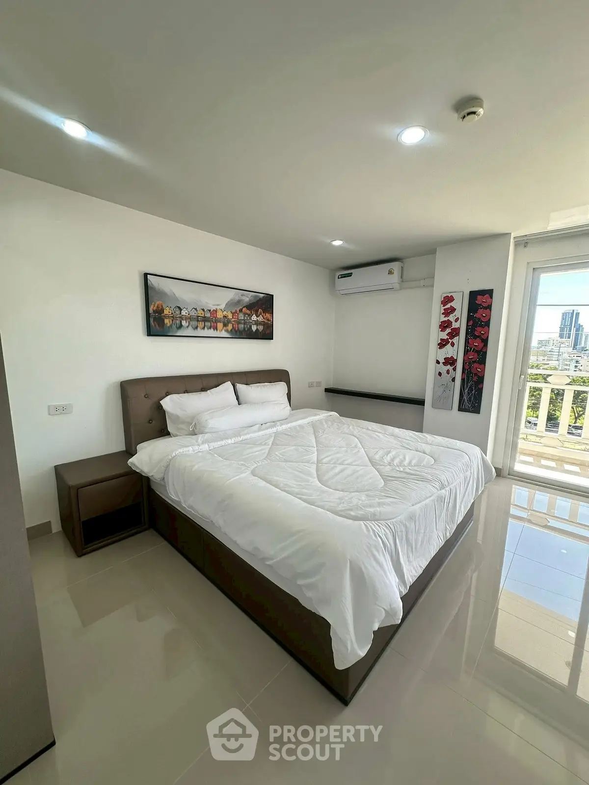 Modern bedroom with city view and stylish decor in high-rise apartment.