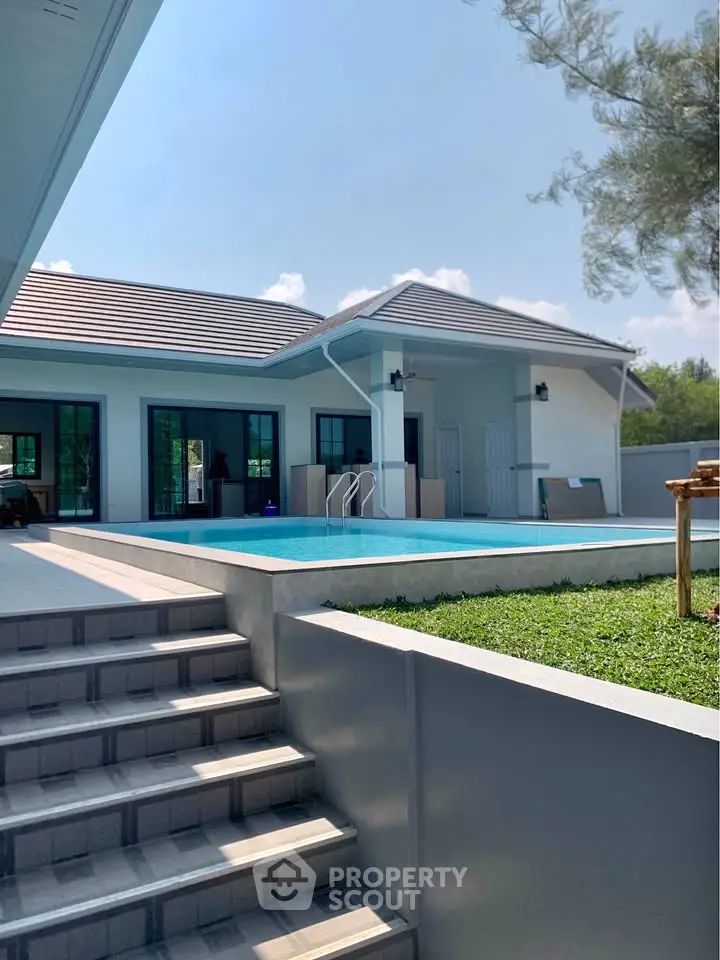 Modern single-story home with private pool and lush greenery, perfect for luxury living.