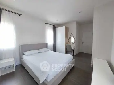 Spacious modern bedroom with elegant decor and ample natural light