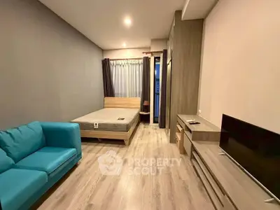 Modern bedroom with cozy blue sofa and sleek wooden furniture