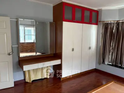 Spacious bedroom with built-in wardrobe and vanity in modern home.