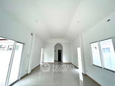 Spacious modern living room with high ceilings and large windows for natural light.