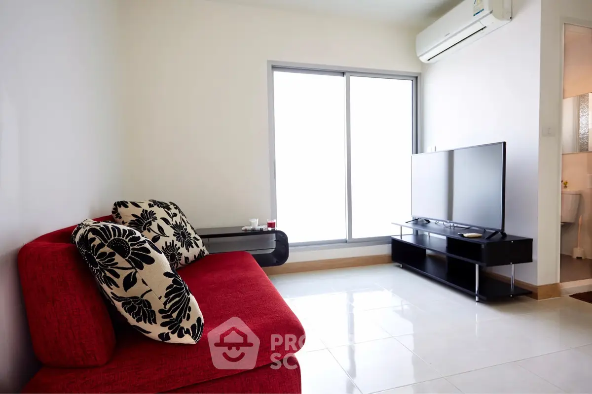 Modern living room with red sofa and large TV, bright natural light