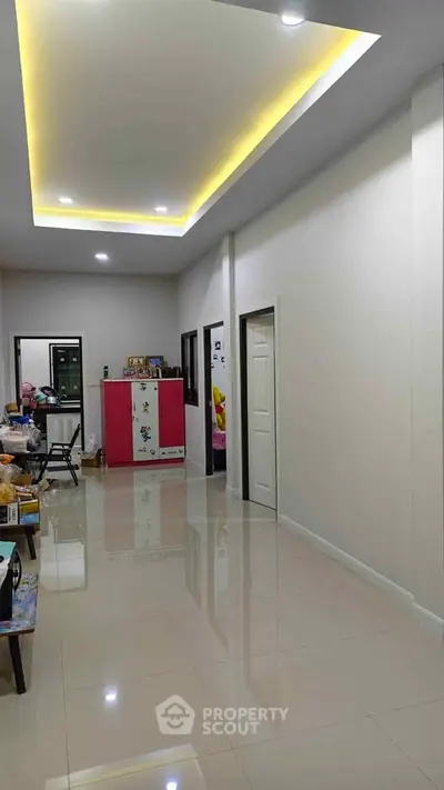 Spacious modern interior with glossy tiled floors and ambient ceiling lighting, perfect for stylish living.