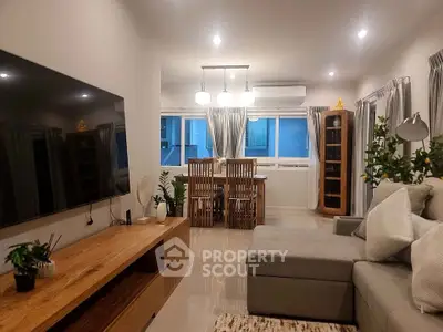 Spacious living room with modern decor and large TV, perfect for relaxation.