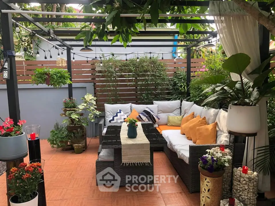 Charming garden patio with cozy seating and lush greenery, perfect for relaxation and outdoor gatherings.