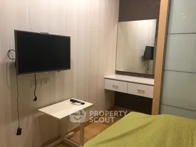 Modern bedroom with wall-mounted TV and stylish vanity area
