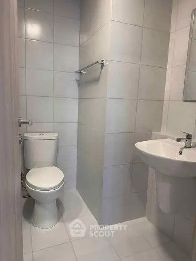 Modern minimalist bathroom with sleek fixtures and neutral tiles, perfect for a contemporary home.