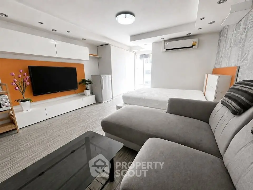 Modern studio apartment with sleek design, featuring a cozy living area, stylish furniture, and ample natural light.