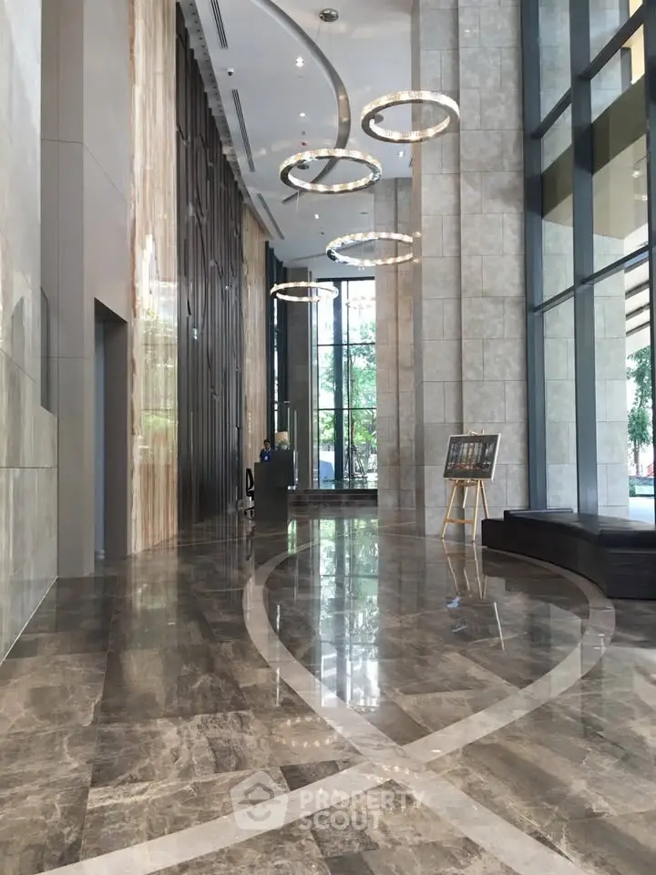 Luxurious modern building lobby with high ceilings and elegant lighting fixtures.