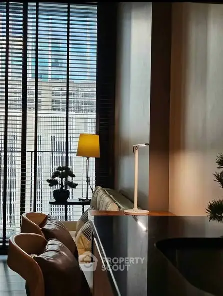 Modern living room with floor-to-ceiling windows and stylish decor in urban apartment.