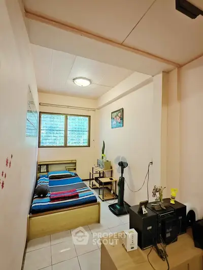 Cozy bedroom with natural light and simple decor, perfect for comfortable living.