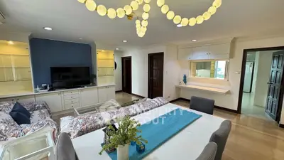 Spacious living room with elegant decor and modern lighting in a stylish apartment.