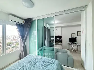 Modern bedroom with city view and glass partition to living area.