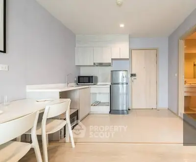 Modern kitchen with sleek appliances and dining area in stylish apartment