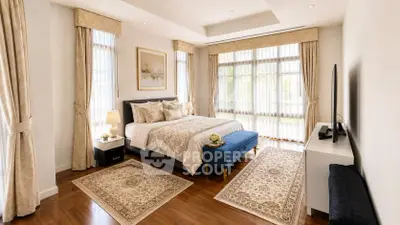 Luxurious bedroom with elegant decor, large windows, and stylish furnishings in a modern home.