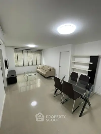 Spacious modern living room with sleek furniture and dining area, perfect for entertaining.