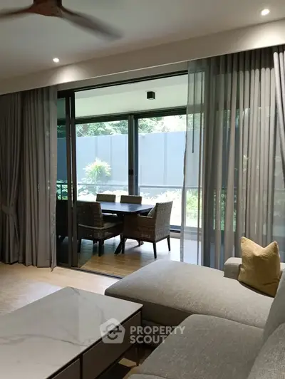 Spacious living room with sliding doors to a cozy balcony, perfect for relaxation.