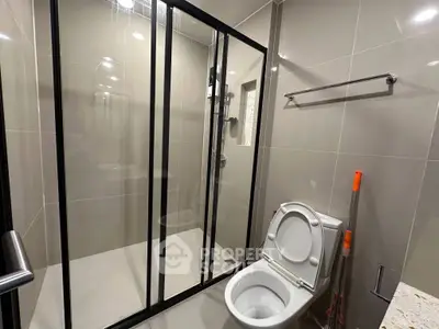 Modern bathroom with glass shower and sleek fixtures in contemporary design.
