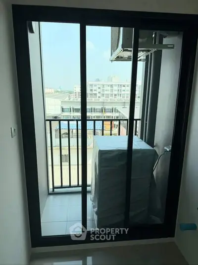 Compact balcony with city view and air conditioning unit, ideal for urban living.