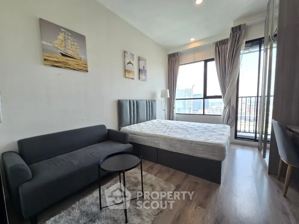 Modern studio apartment with cozy furnishings and city view balcony