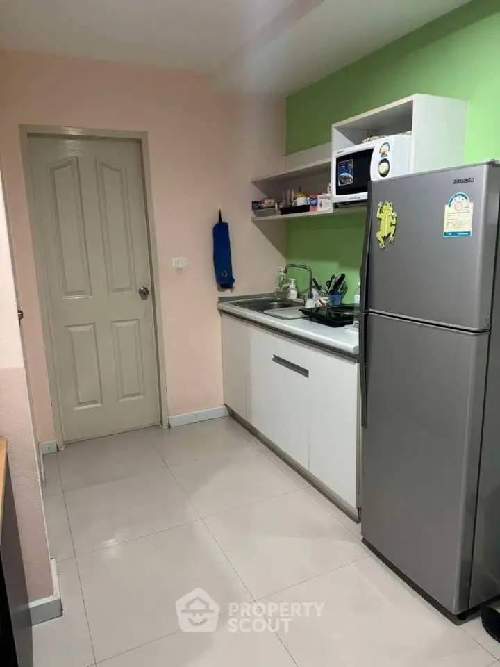 Modern kitchen with sleek appliances and vibrant green accent wall, perfect for culinary enthusiasts.